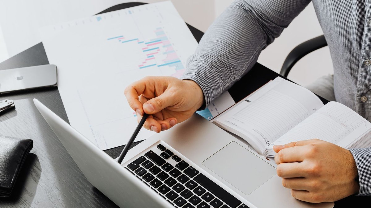 Pessoa pesquisando no notebook com anotações ao lado, comparando respostas de buscadores com IA
