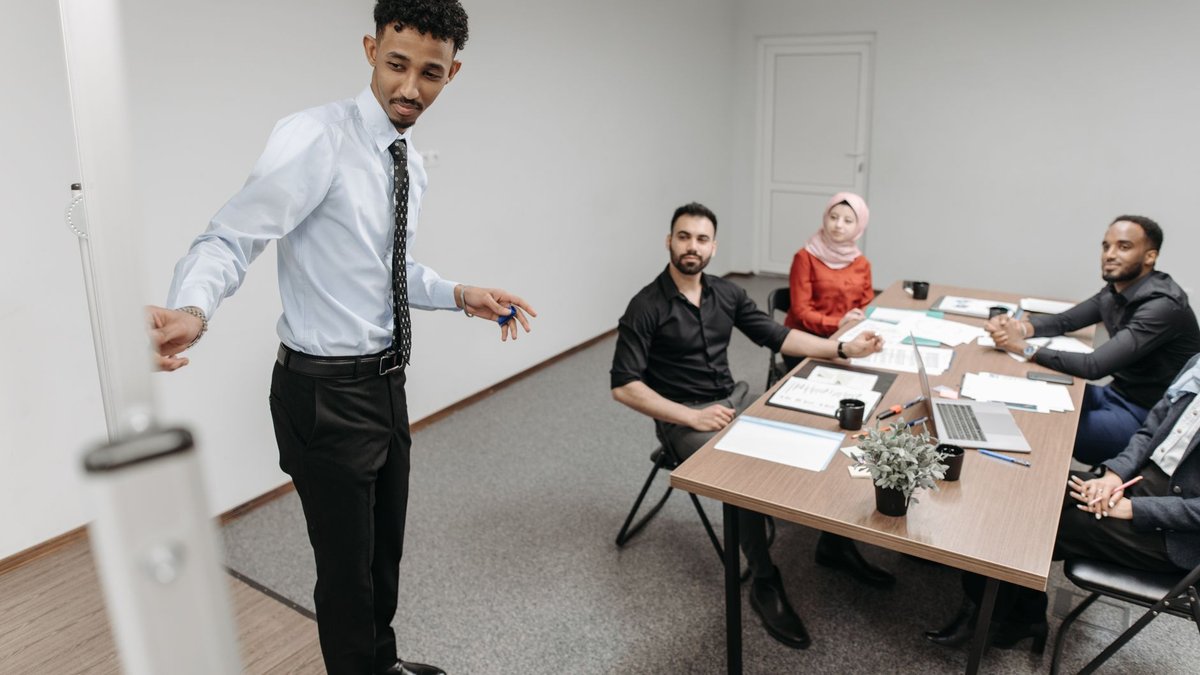 Pessoa apresentando para colegas em uma sala de reunião, ilustrando o uso de IA para preparar apresentações