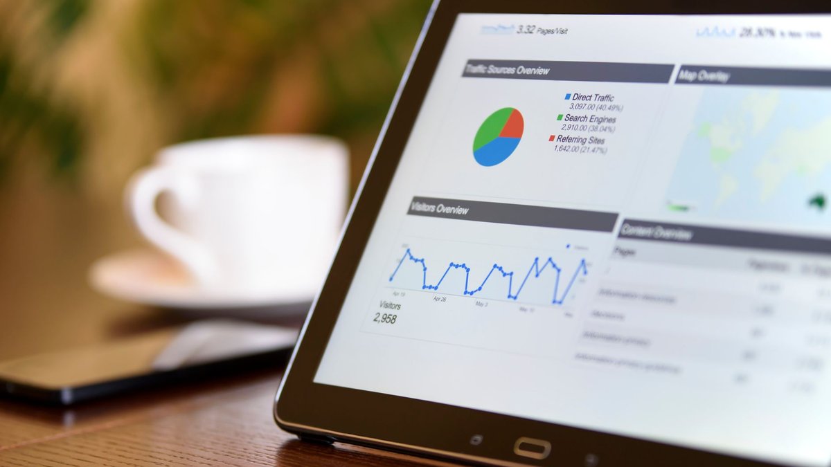 Tablet mostrando painel de analytics com gráfico de tráfego e visitantes